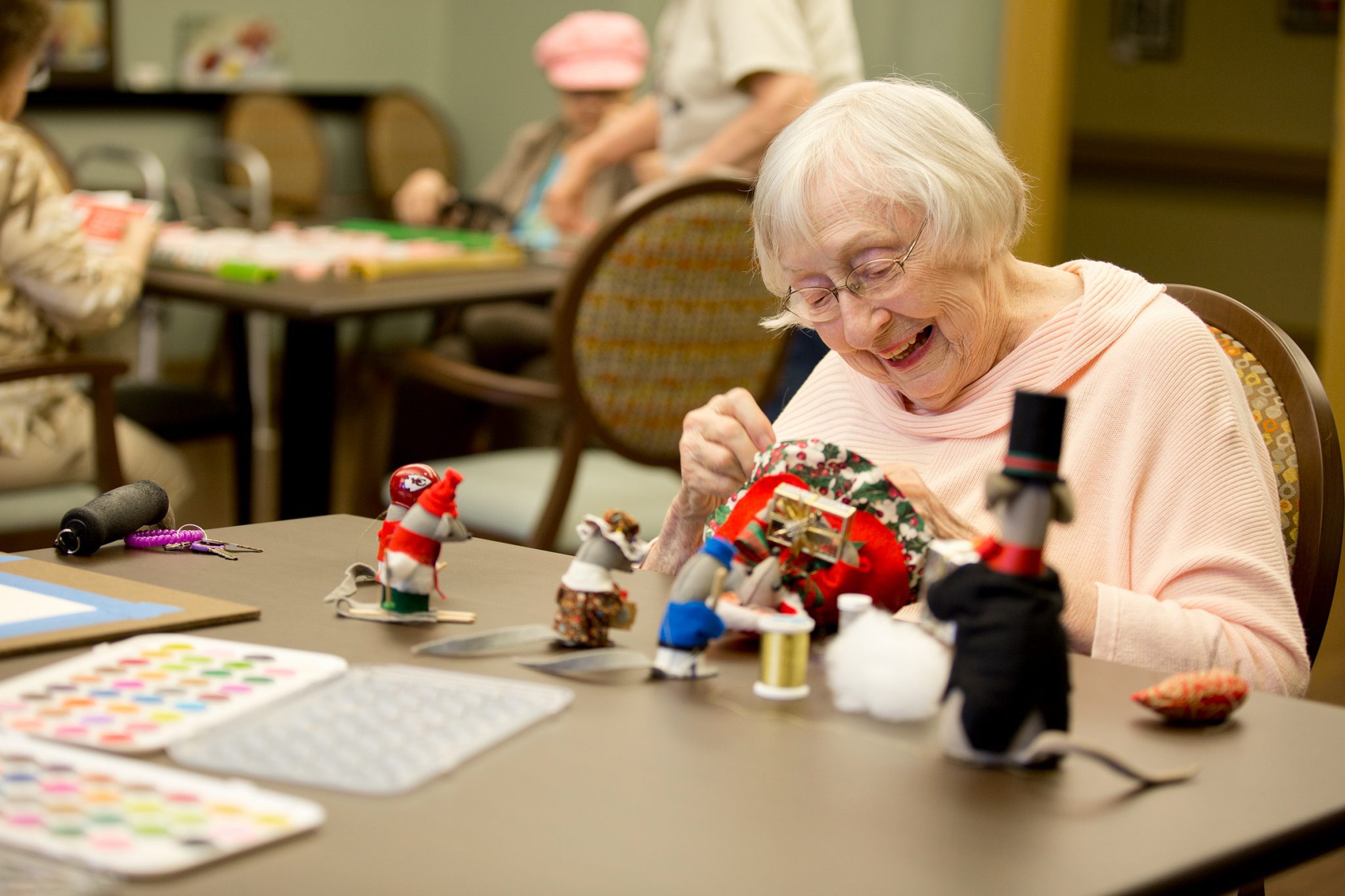 A women sowing in the art room at Kingswood Senior Living Located in Kansas City, MO.