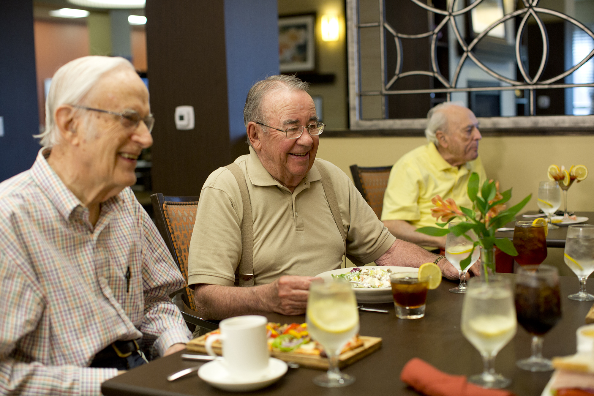 Three men eating in the bistro at Kingswood Senior Living Located in Kansas City, MO.