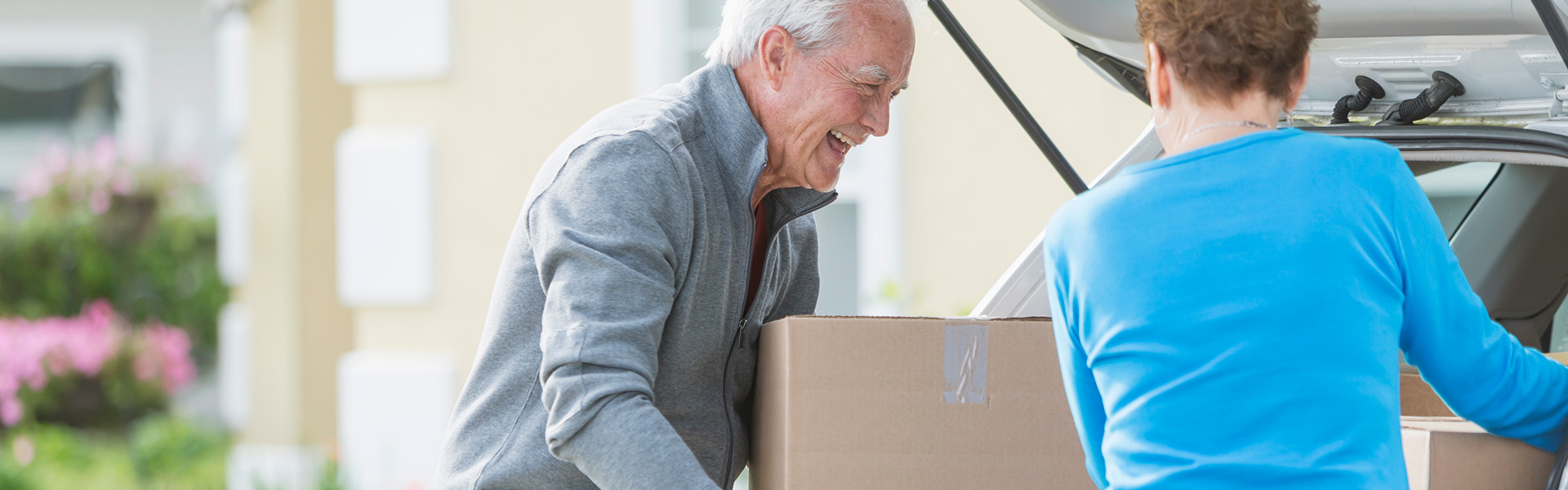 A couple taking moving boxes out of a car at Kingswood Senior Living Located in Kansas City, MO.