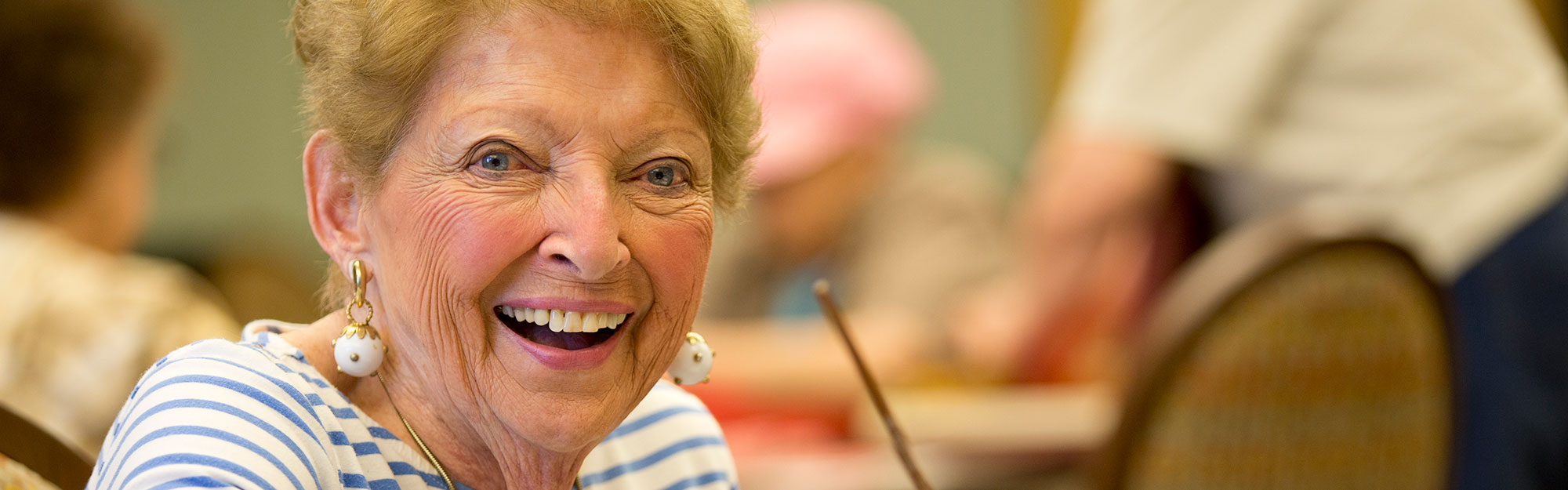 A women looking at the camera and smiling at Kingswood Senior Living Located in Kansas City, MO.