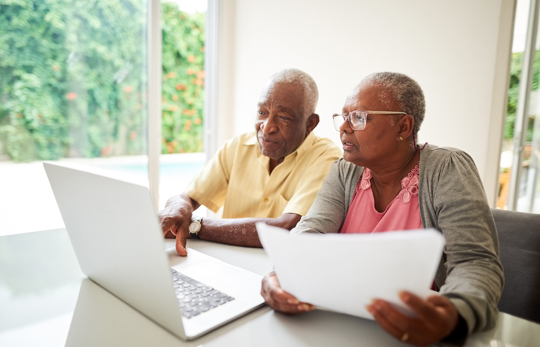 Couple looking at finances and a computer to prepare to compare a Entrance Fee vs. Rental Community